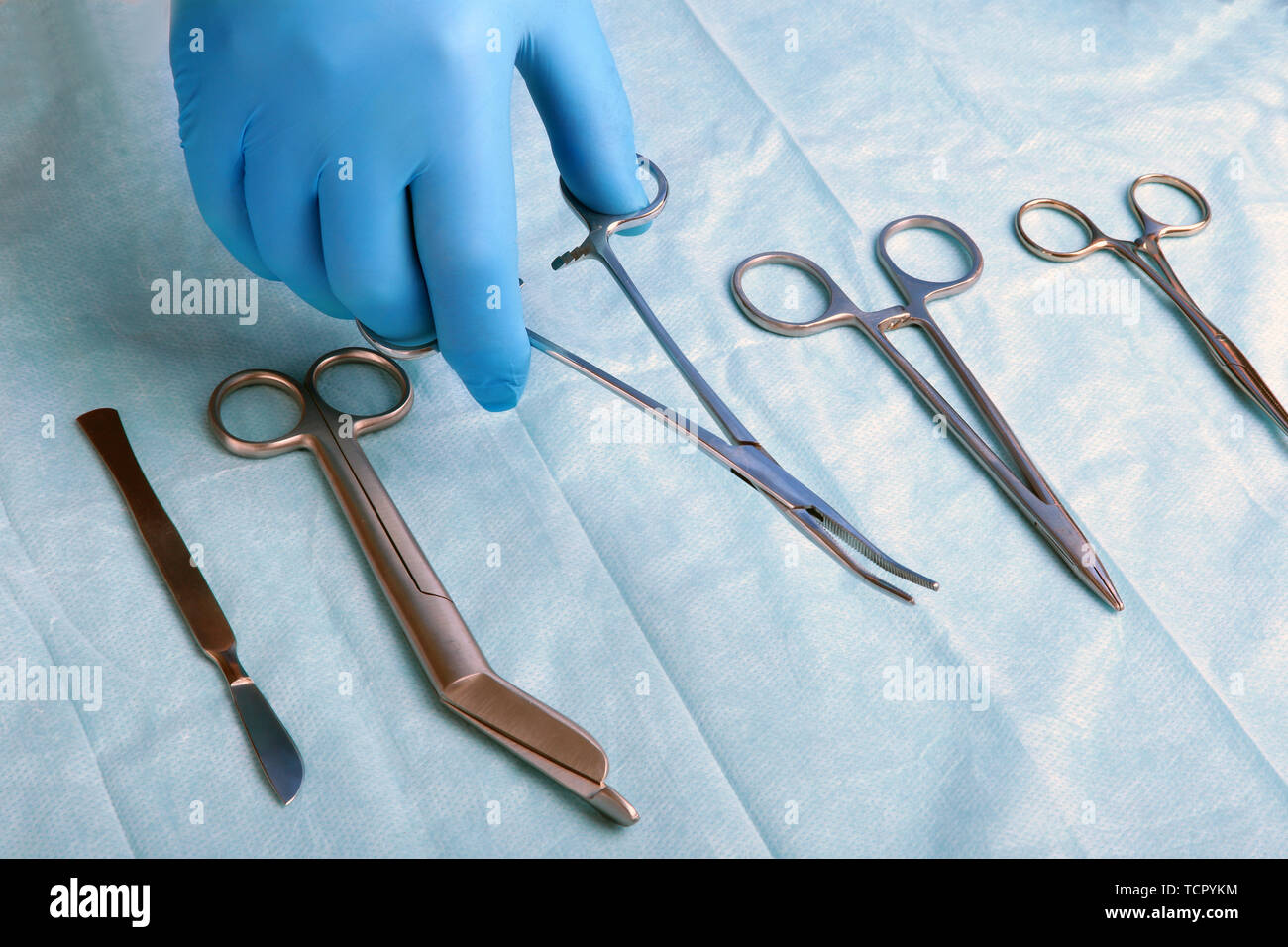 Detail shot of sterilized surgery instruments with a hand grabbing a