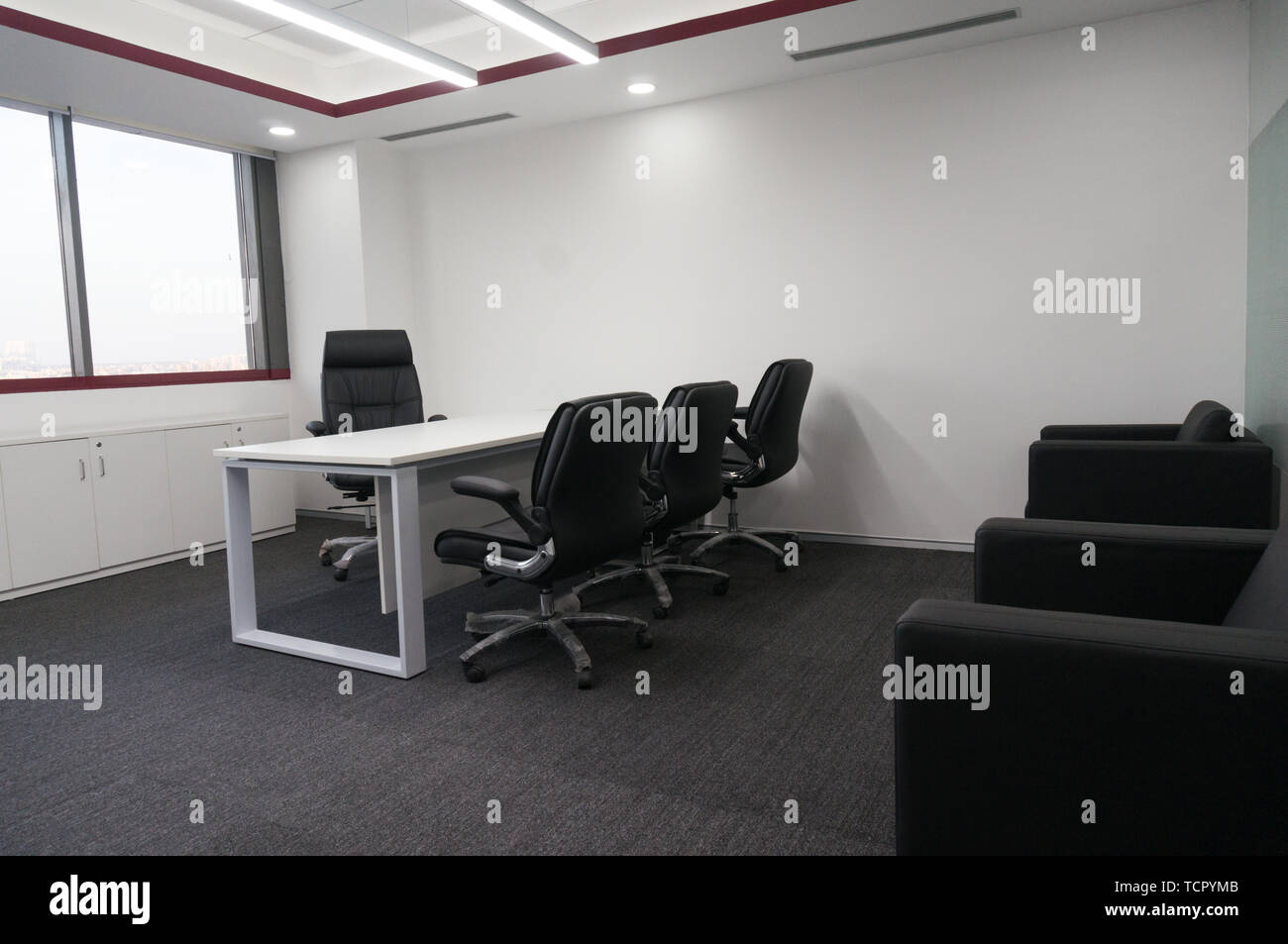 large corner office with executive desk and seating area Stock Photo