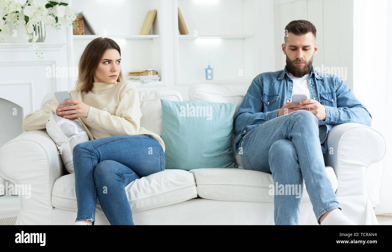 Couple Crisis. Man Using Phone, Not Paying Attention To Wife Stock Photo