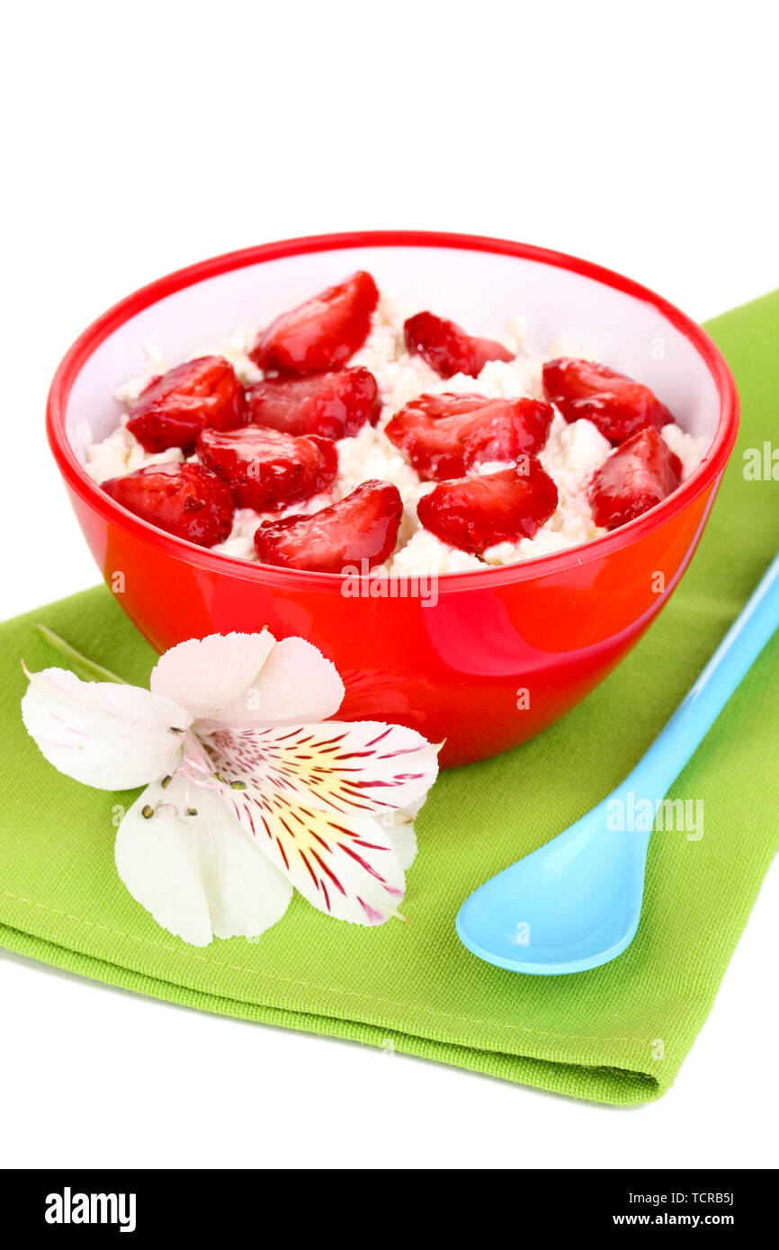 Cottage cheese in red bowl with sliced strawberries isolated on white
