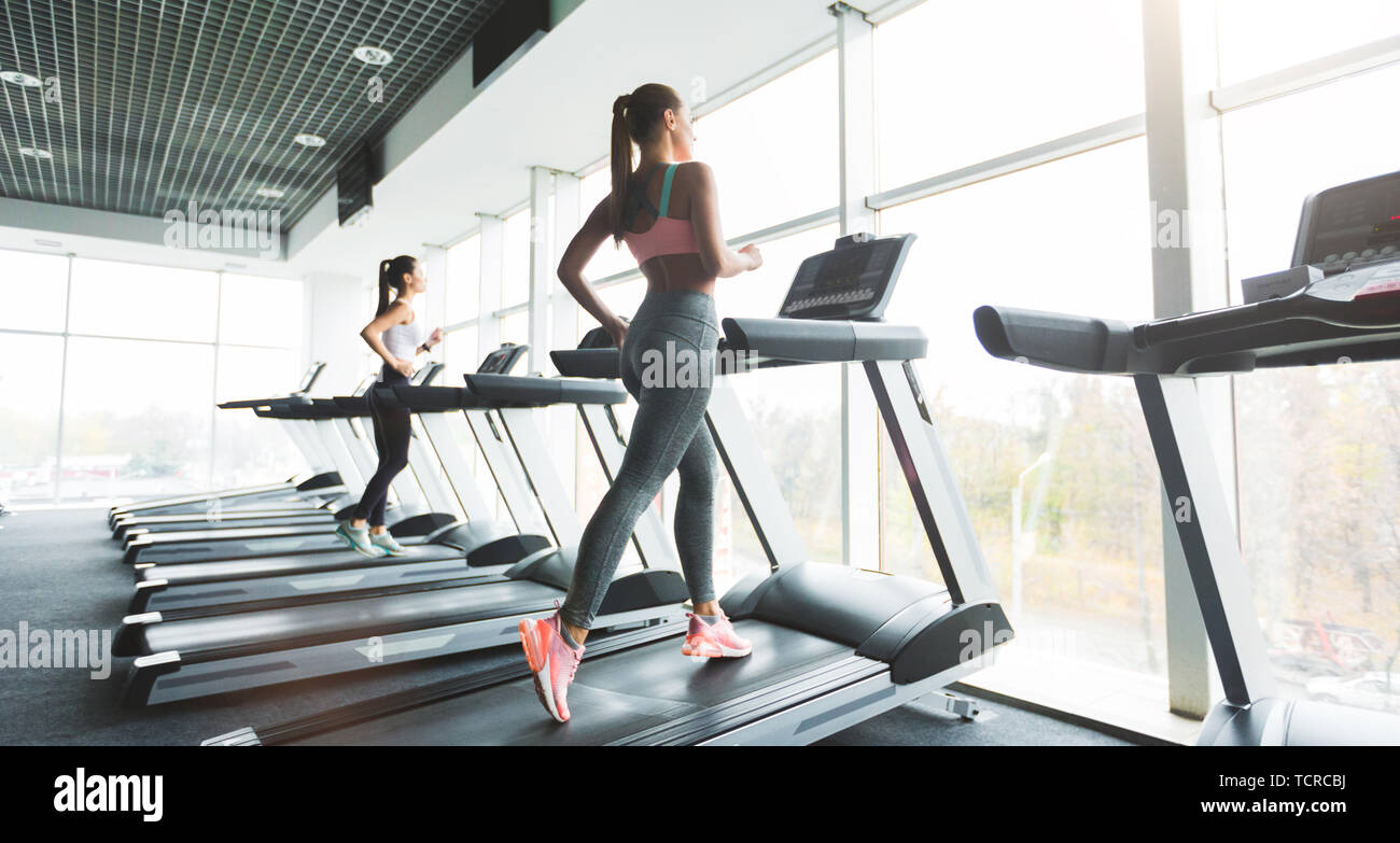 Doing cardio training. Sports woman working out in gym Stock Photo