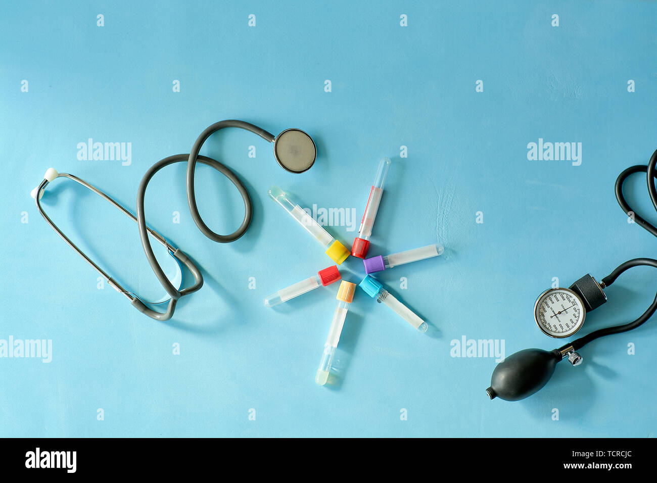 Phonendoscope stethoscope, sphygmomanometer, vacuum test tubes on blue