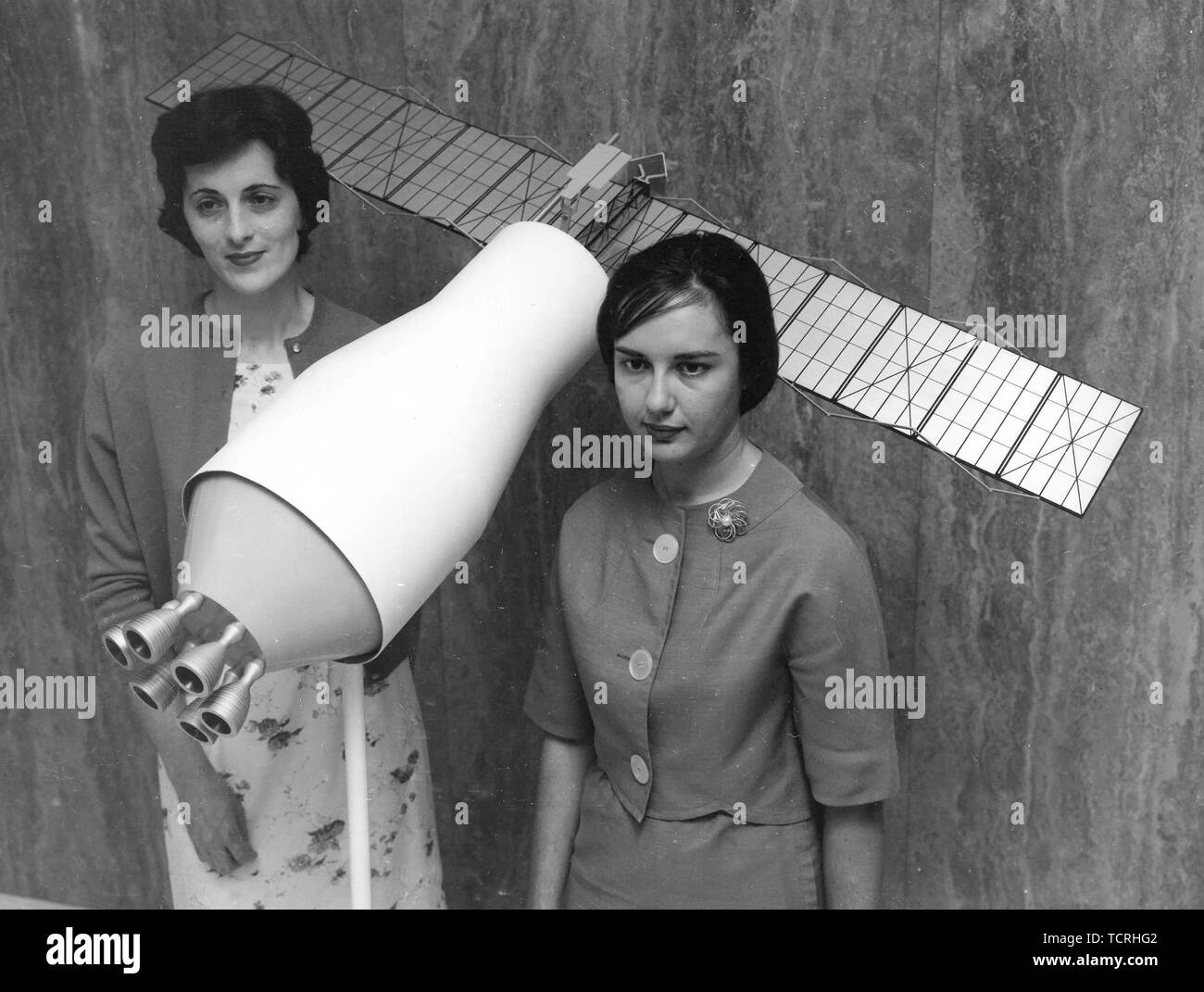 Ann McNair and Mary Jo Smith pose with a model of a Pegasus Satellite Stock Photo