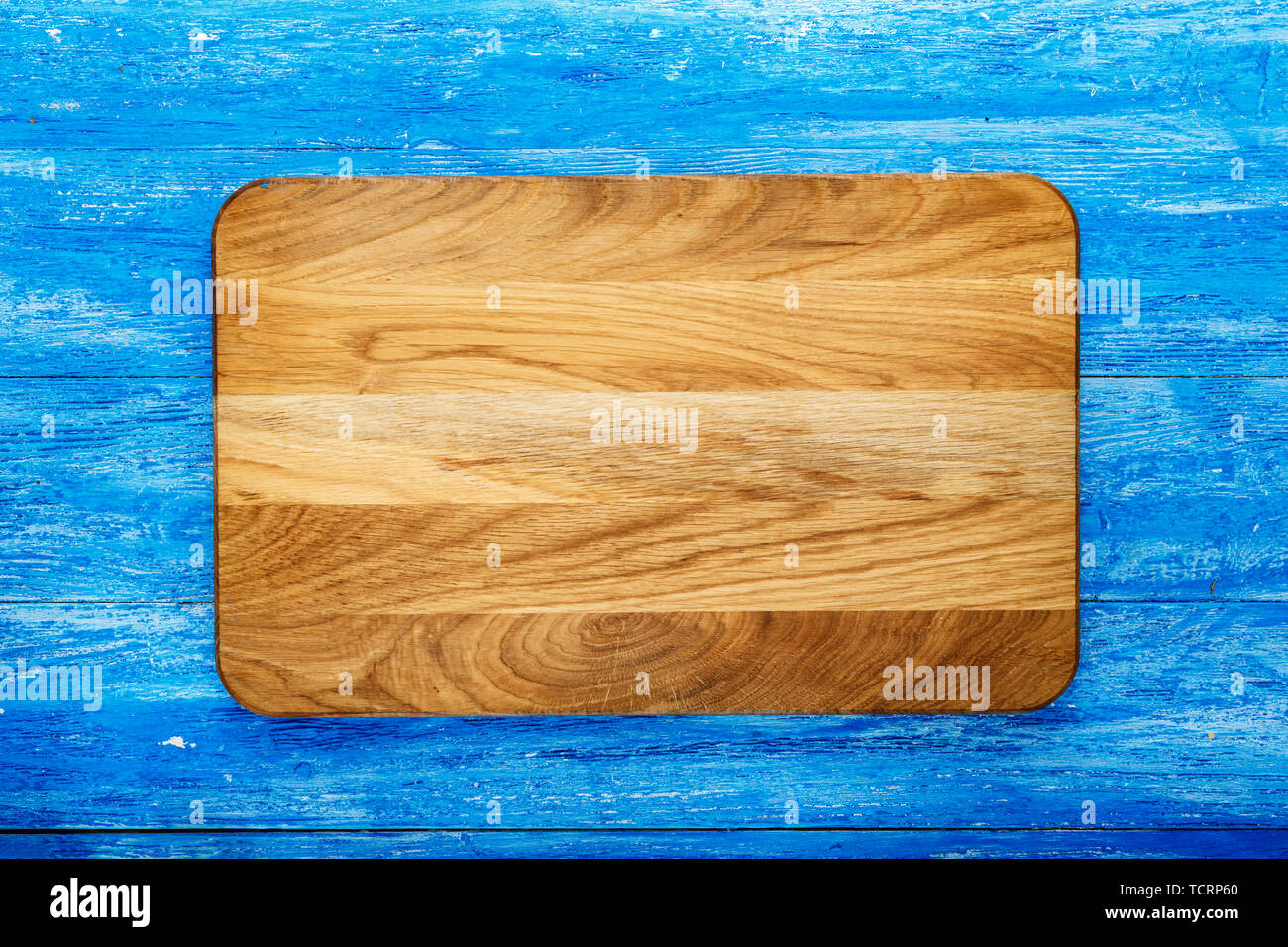 Rectangular wooden cutting board on a wooden background. space for text Stock Photo