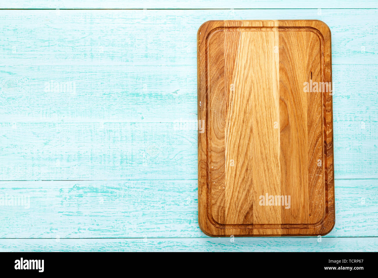 Rectangular wooden cutting board on a wooden background. space for text Stock Photo