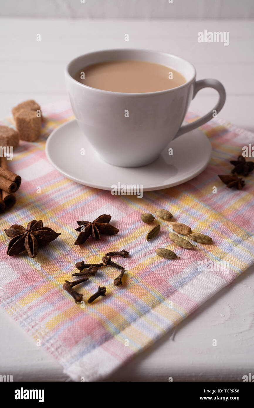 Indian traditional Masala chai tea in a mug and kitchen herbs, over ...