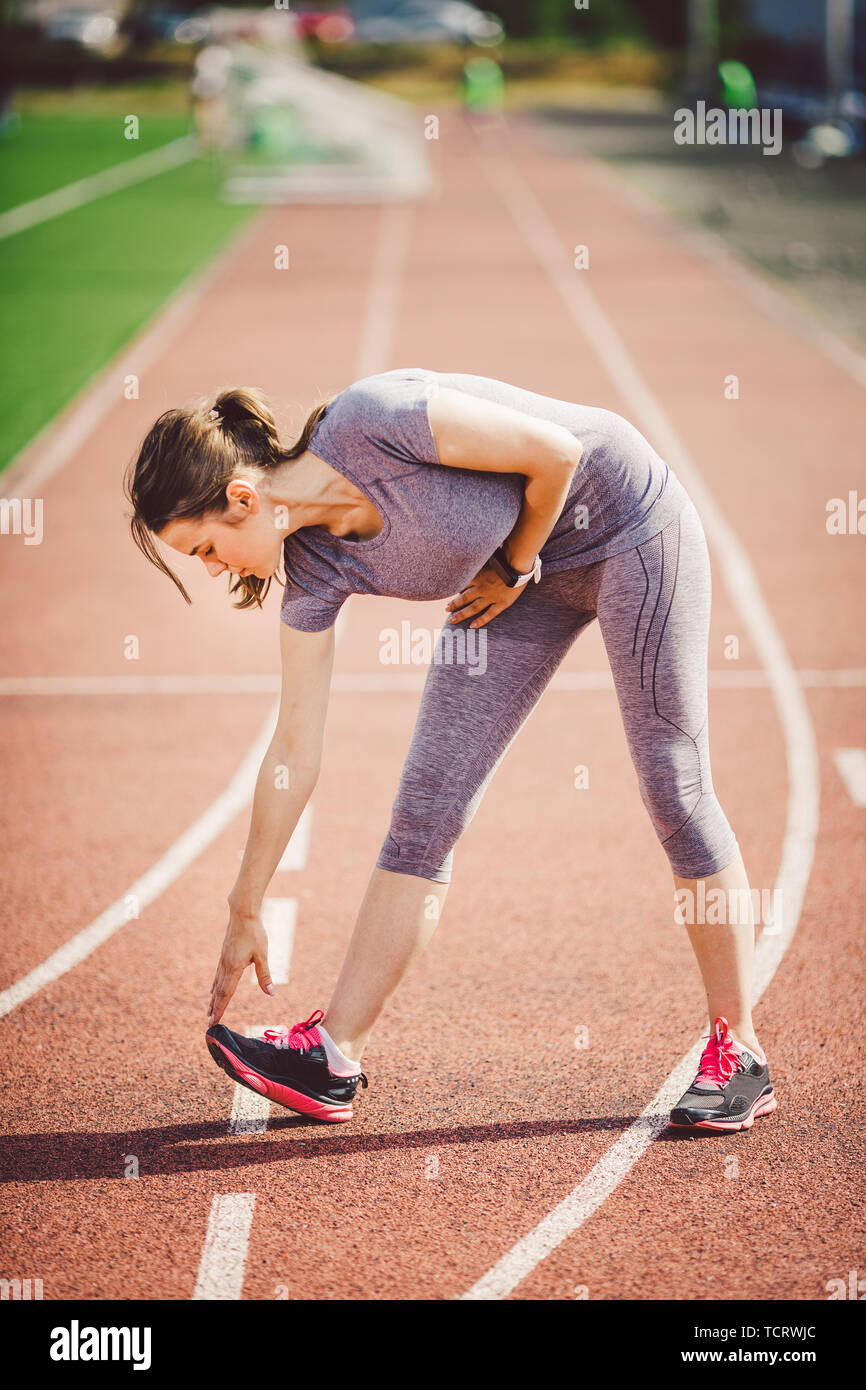 Beautiful young caucasian woman with long hair in tail and big breasts  doing exercises, warming up and warming up muscles before training in  running s Stock Photo - Alamy