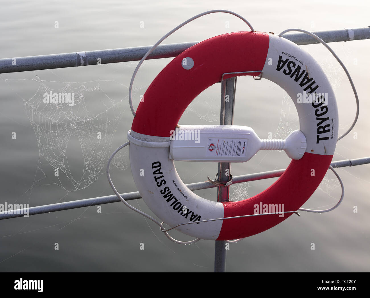 Trygg-hansa rescue buoy hanging off a metal fence at Karlsudd jetty near  Vaxholm, Sweden Stock Photo - Alamy