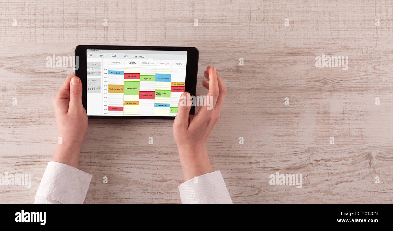Hand holding tablet with timetable and calendar concept Stock Photo - Alamy