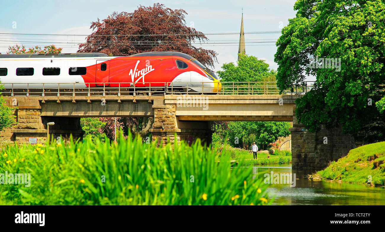 Virgin inter city train passing over a bridge on the Lancaster Canal at Lancaster on a sunny day Stock Photo