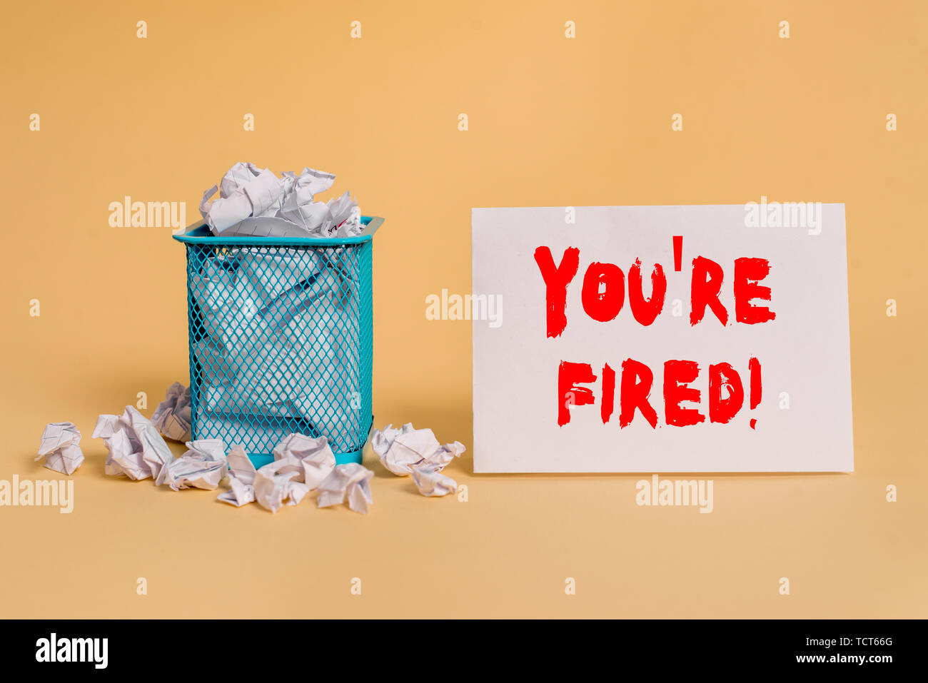 Handwriting text You Re Fired. Conceptual photo Used by boss indicate employee that he is discharged from job crumpled paper trash and stationary with Stock Photo