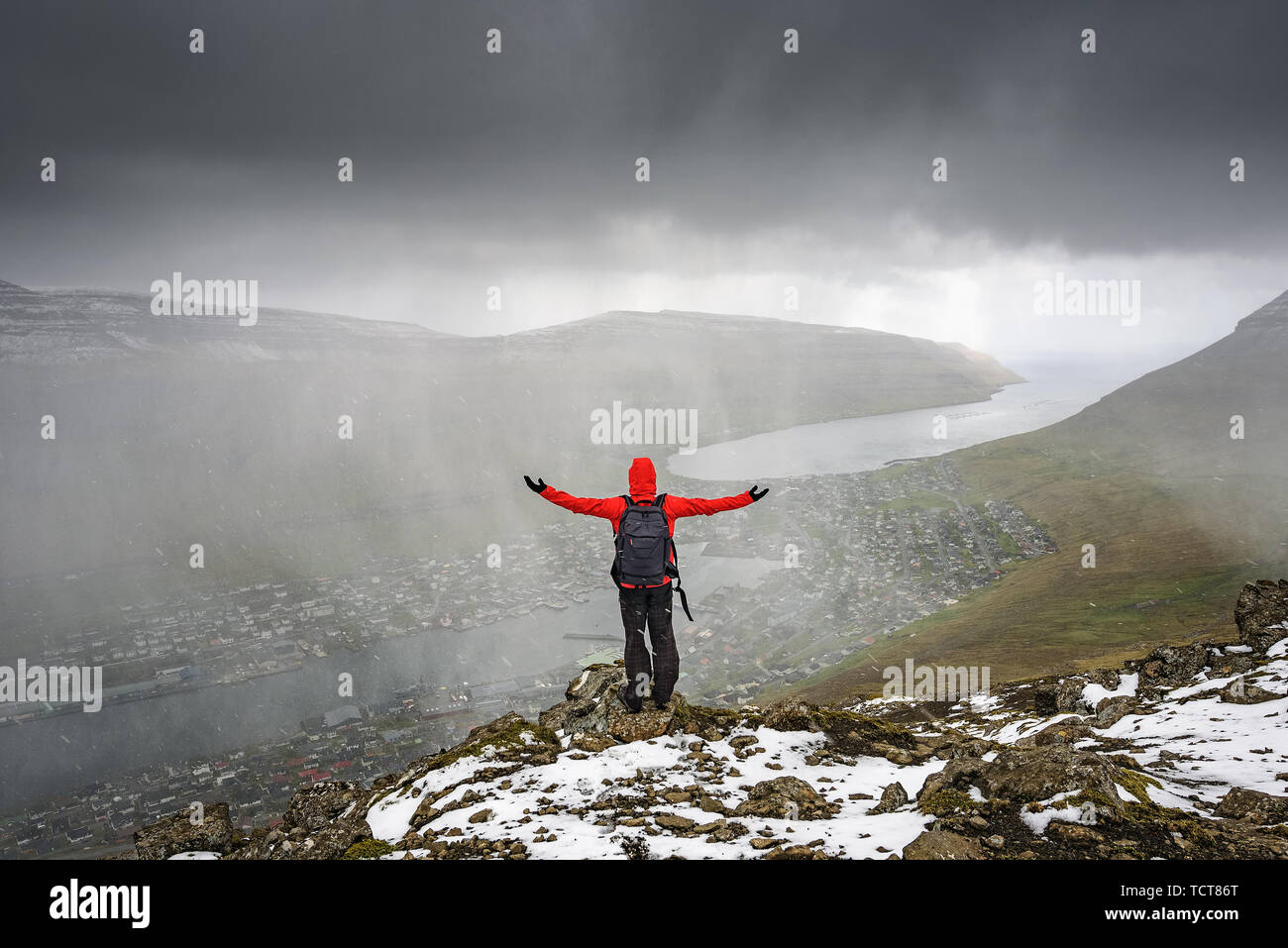Hiker on the Klakkur mountain above the city of Klaksvik on Faroe Islands Stock Photo