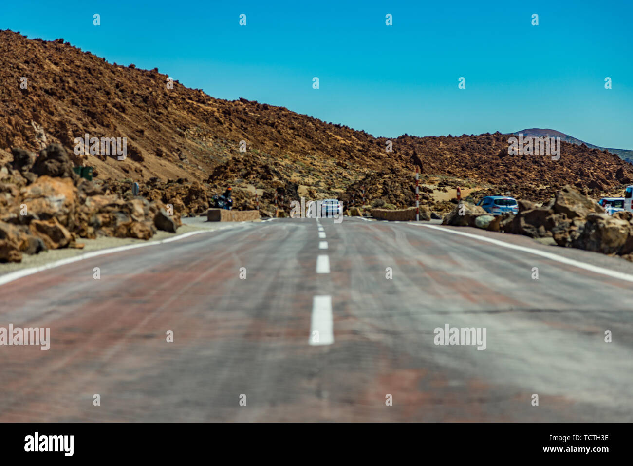Nearest future. Asfalt road crossing Mars landscape. Mountains around volcano Teide. Bright blue sky. Teide National Park, Tenerife, Canary Islands, S Stock Photo