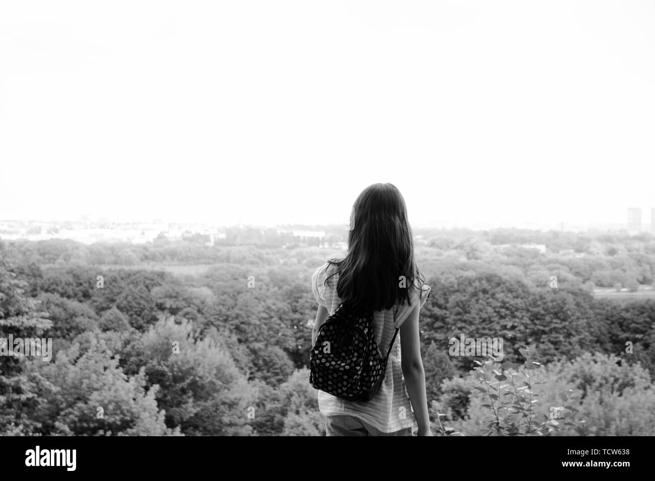 Young girl traveller with a small backpack, while enjoying the amazing views of the city, walking and exploring nature . Expectation Stock Photo