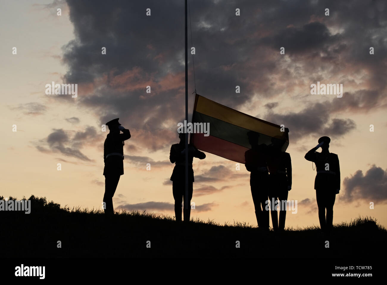 Soldiers Raising The Lithuanian Flag At evening Sunset Stock Photo