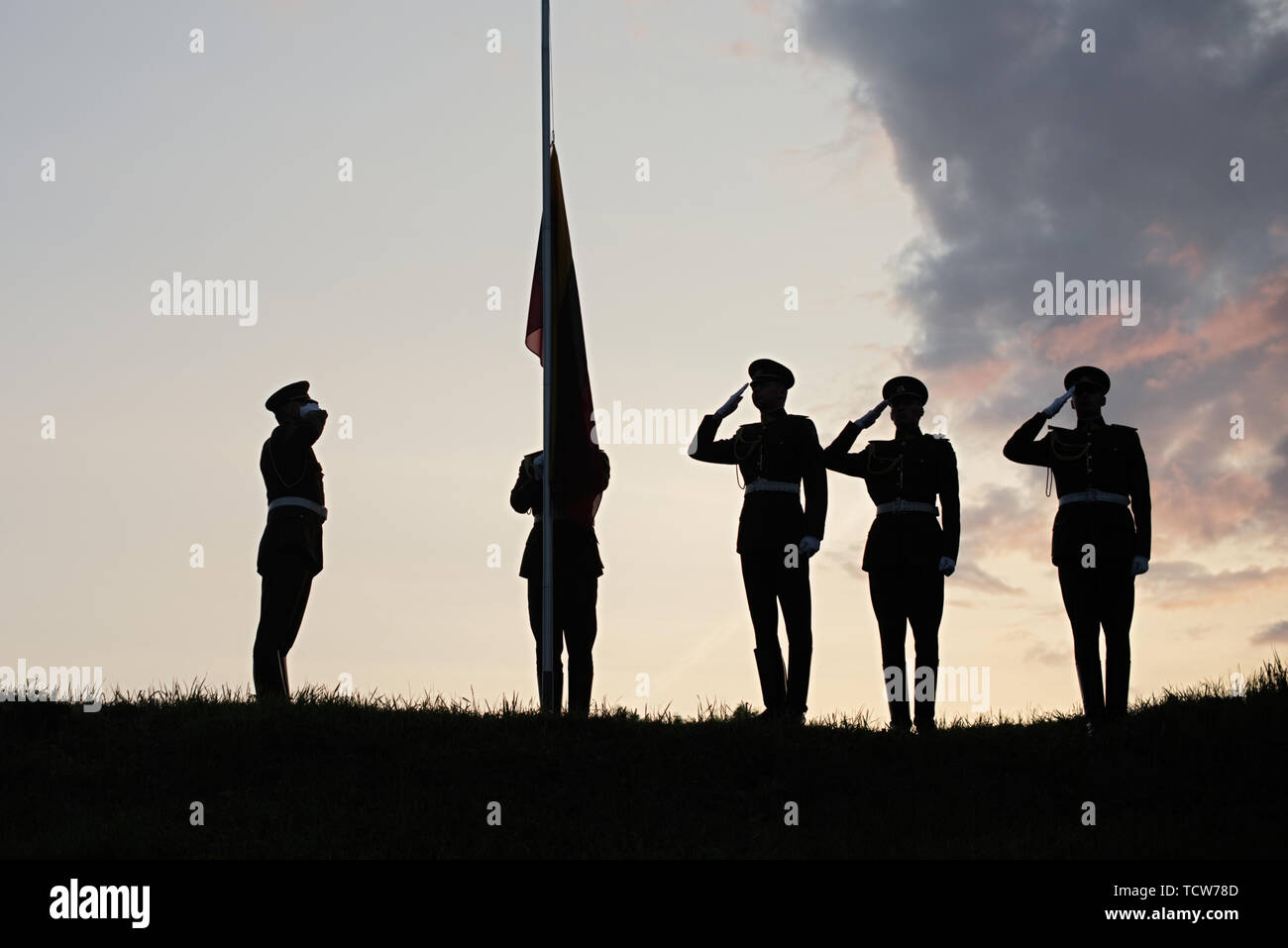 Soldiers Raising The Lithuanian Flag At evening Sunset Stock Photo