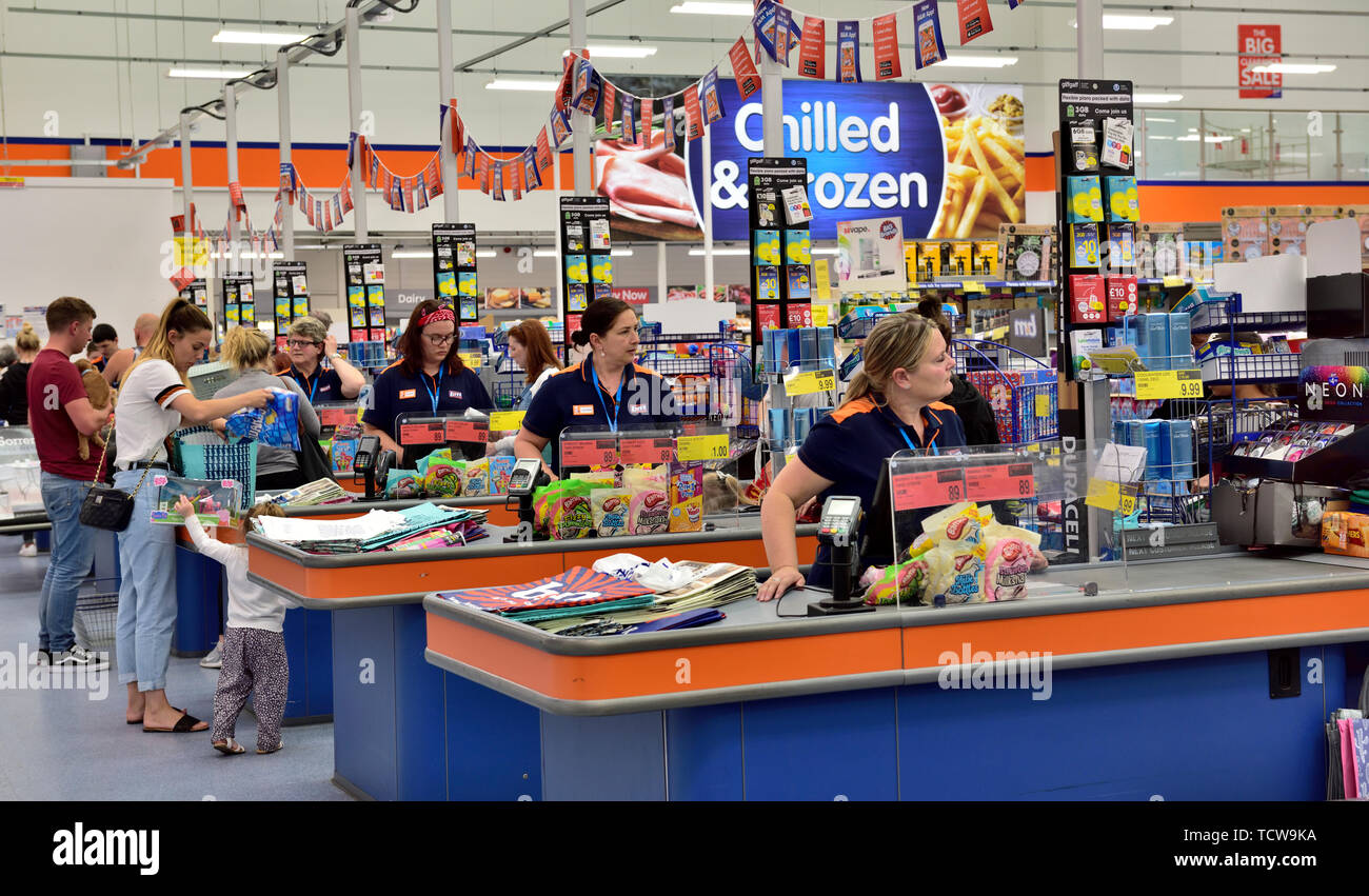 Staff at checkouts in B&M discount store ready to help customers Stock Photo