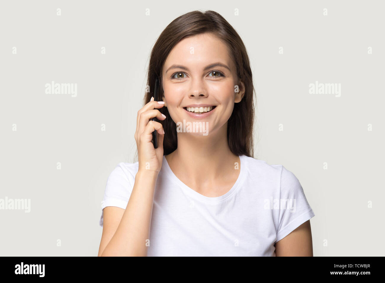 Headshot portrait positive woman talking on phone isolated on grey Stock Photo