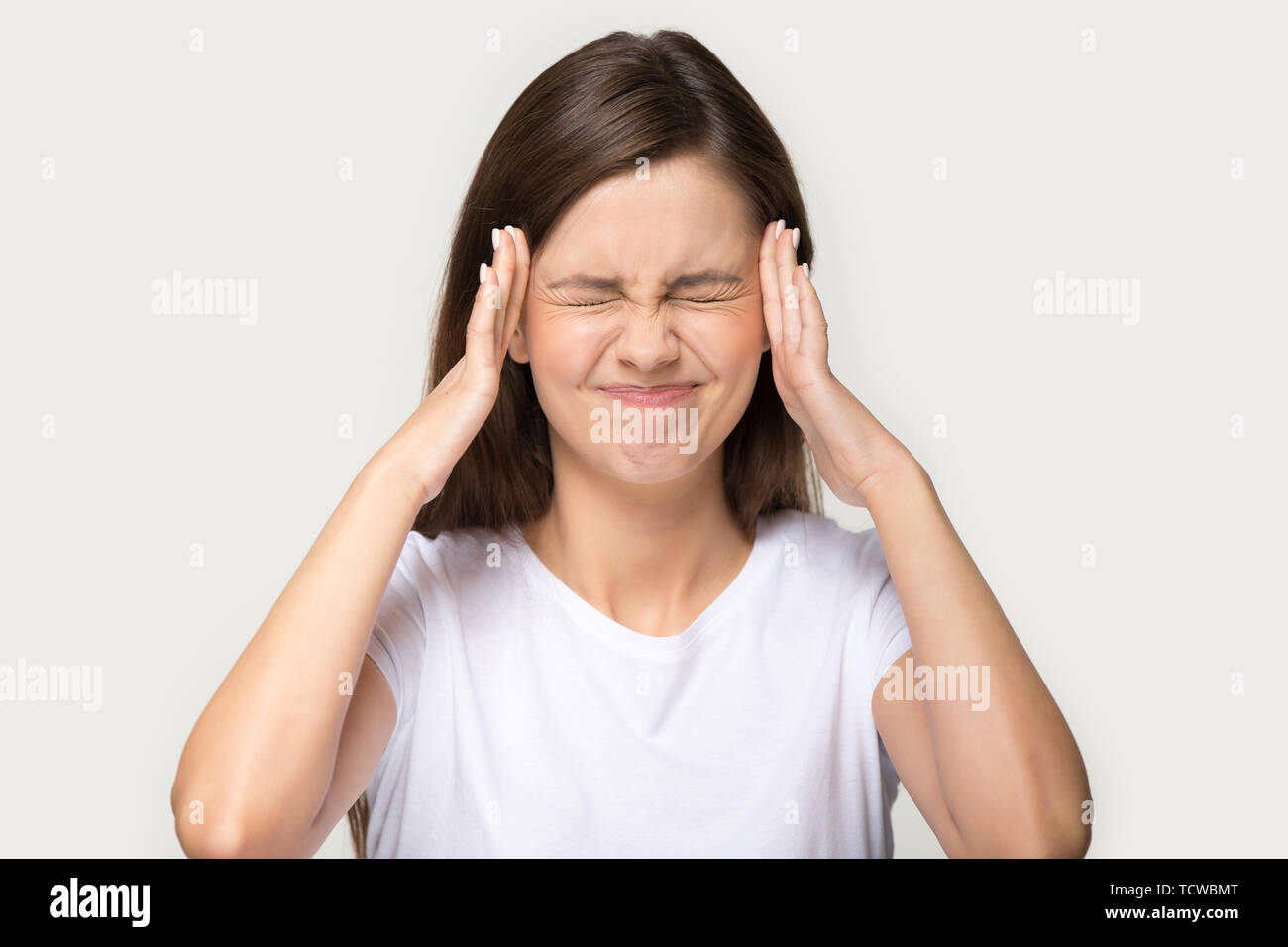Head shot portrait stressed woman touching temples suffers from headache Stock Photo