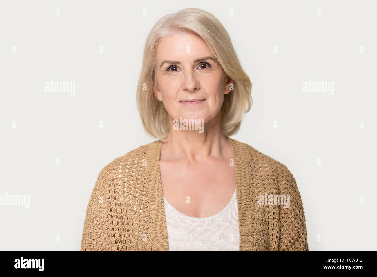 Attractive mature woman looking at camera isolated on grey background Stock Photo