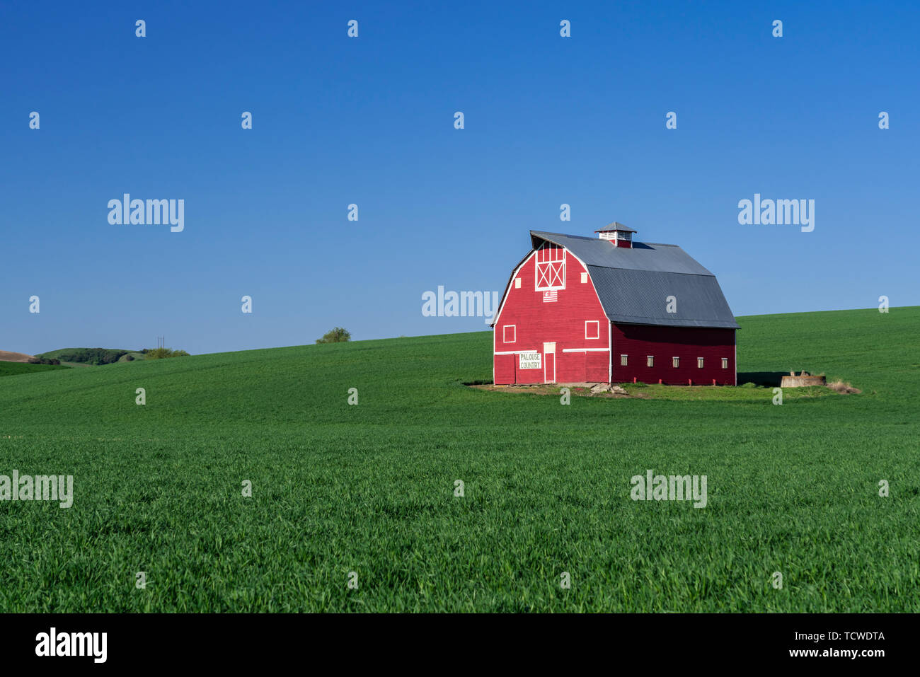 A red barn in the rolling hills of the Palouse region of Washington