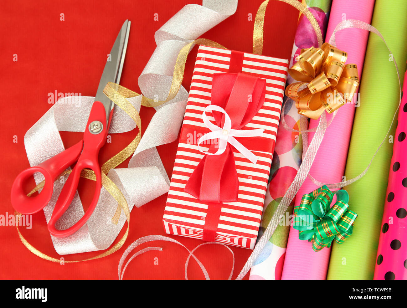 Rolls Of Christmas Wrapping Paper With Ribbons, Bows And Scissors