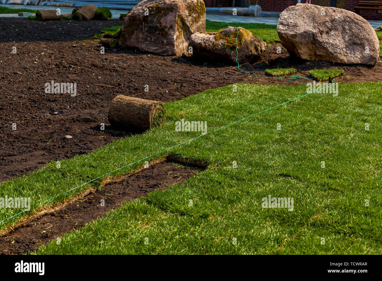 Green grass in rolls for lawn and designer landscape. The stacking of roll green lawn grass
