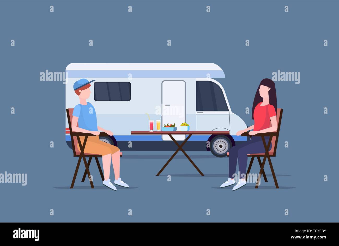 couple sitting at table near camping family trailer truck caravan car ...