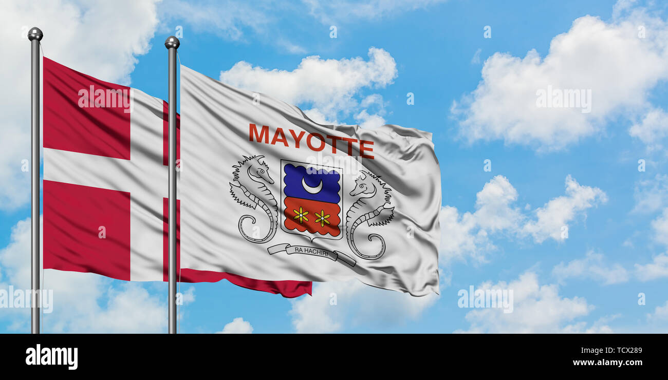 Denmark and Mayotte flag waving in the wind against white cloudy blue sky together. Diplomacy concept, international relations. Stock Photo