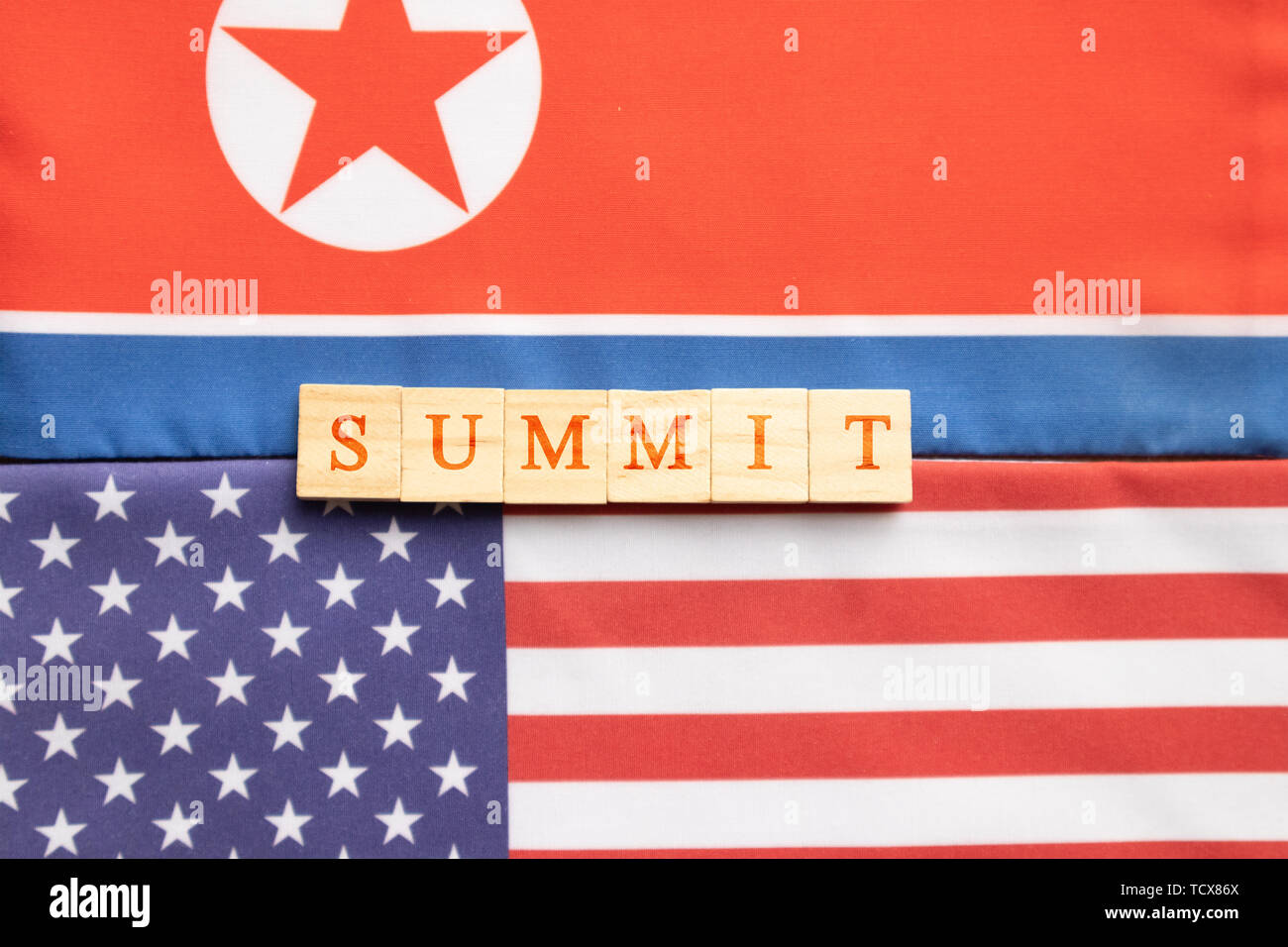 Concept of bilateral relations of USA and North Korea showing with flag and summit in wooden block letters Stock Photo