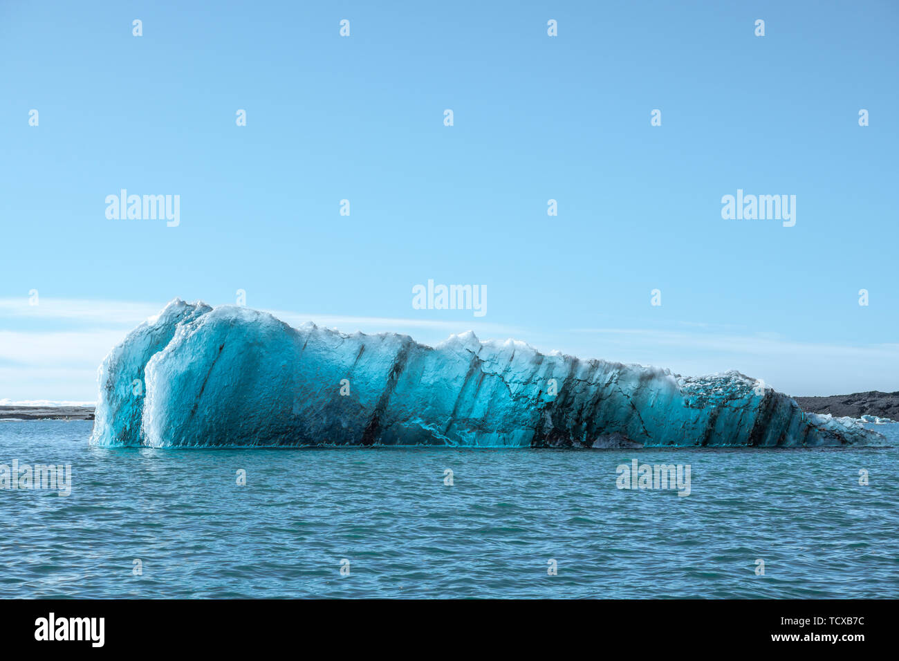 A crystal blue ice iceberg floating in a sponge in the Arctic Ocean