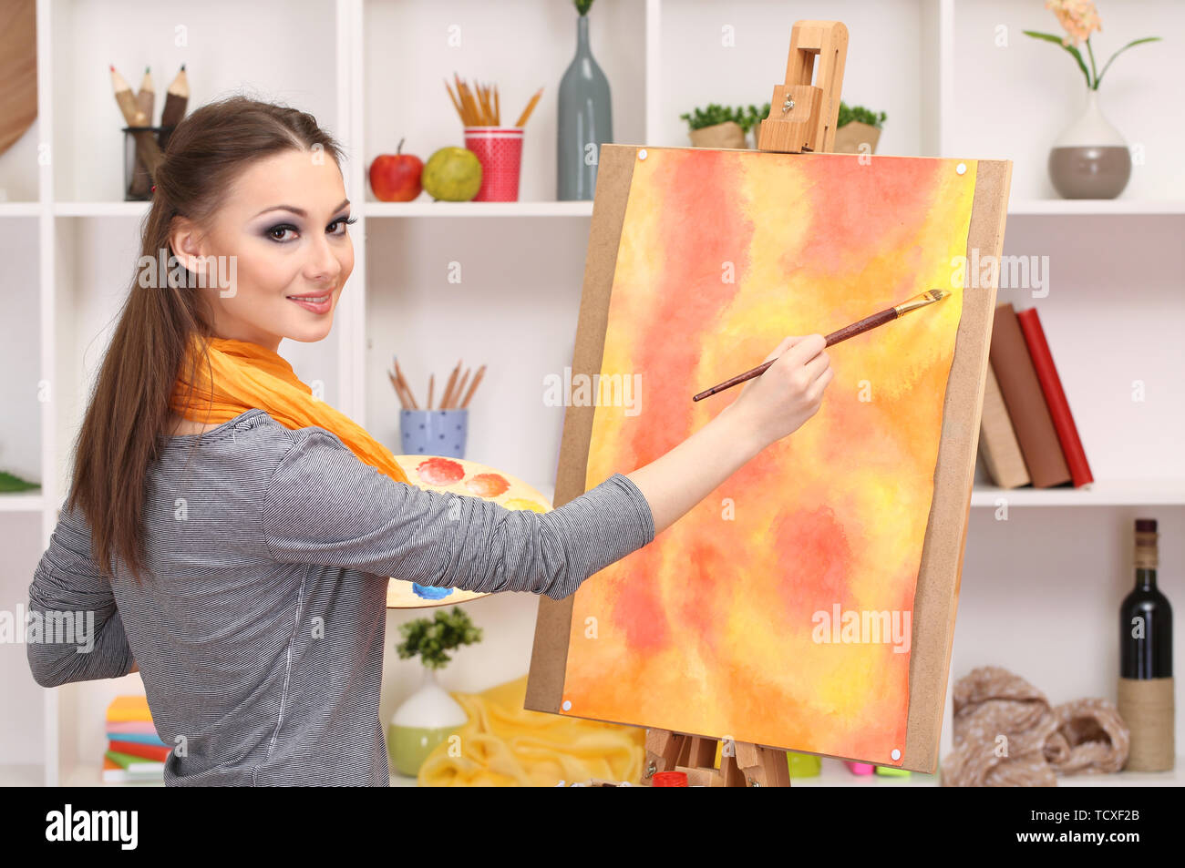 beautiful young woman painter at work, on room interior background Stock Photo