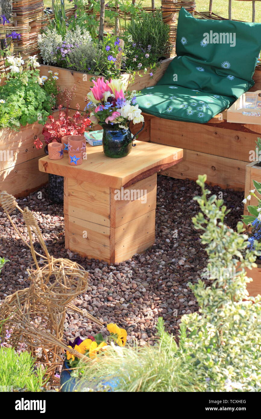 Raised planters and cosy seating in a small urban plot. Show garden by Down 2 Earth Garden Design - Harrogate Spring Flower Show 2019 Stock Photo