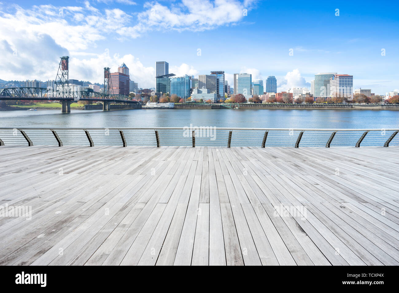 empty wood floor near steel bridge over water with cityscape and skyline of portland Stock Photo