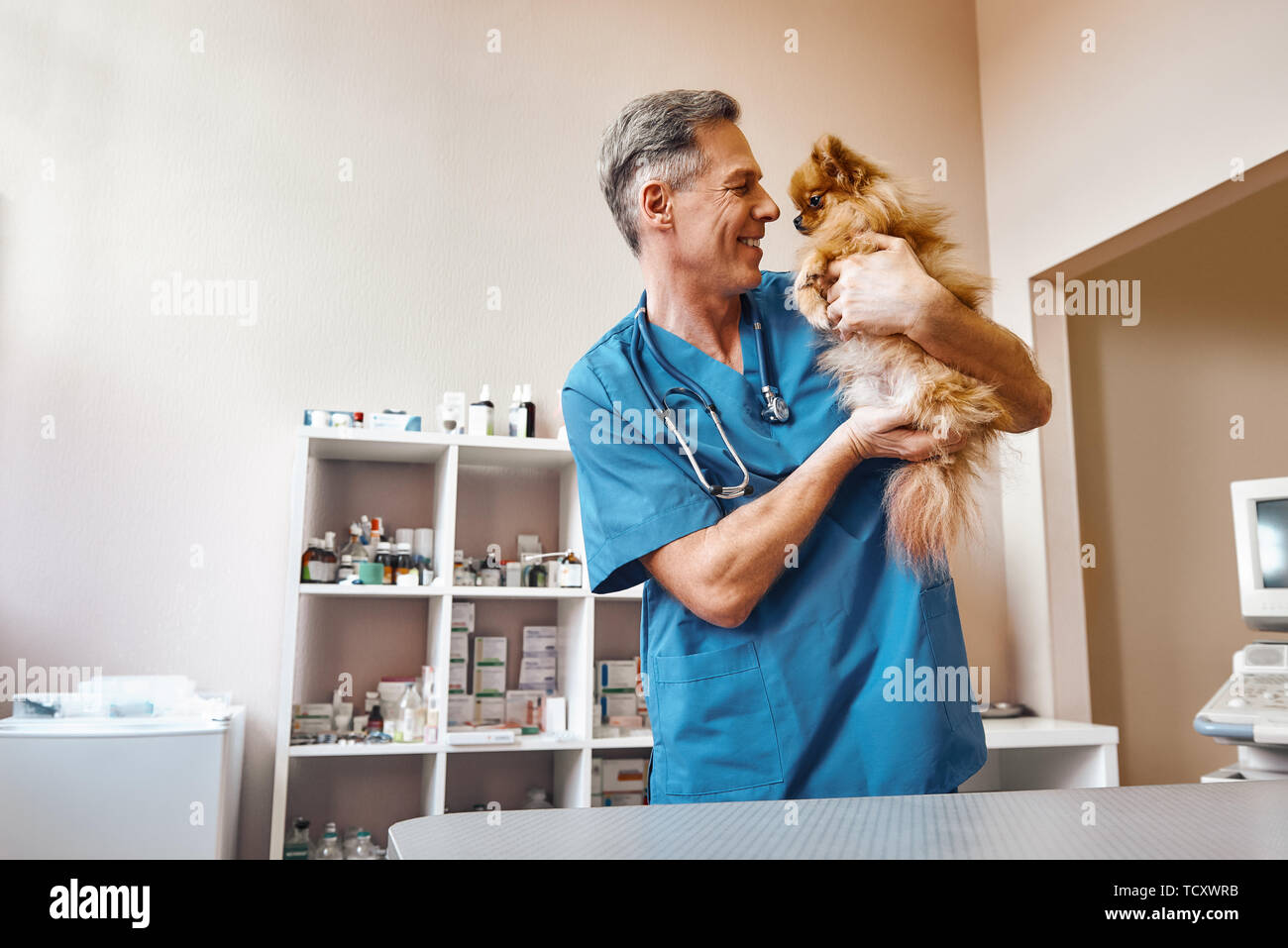 My best part of work! Middle aged positive vet in work uniform talking