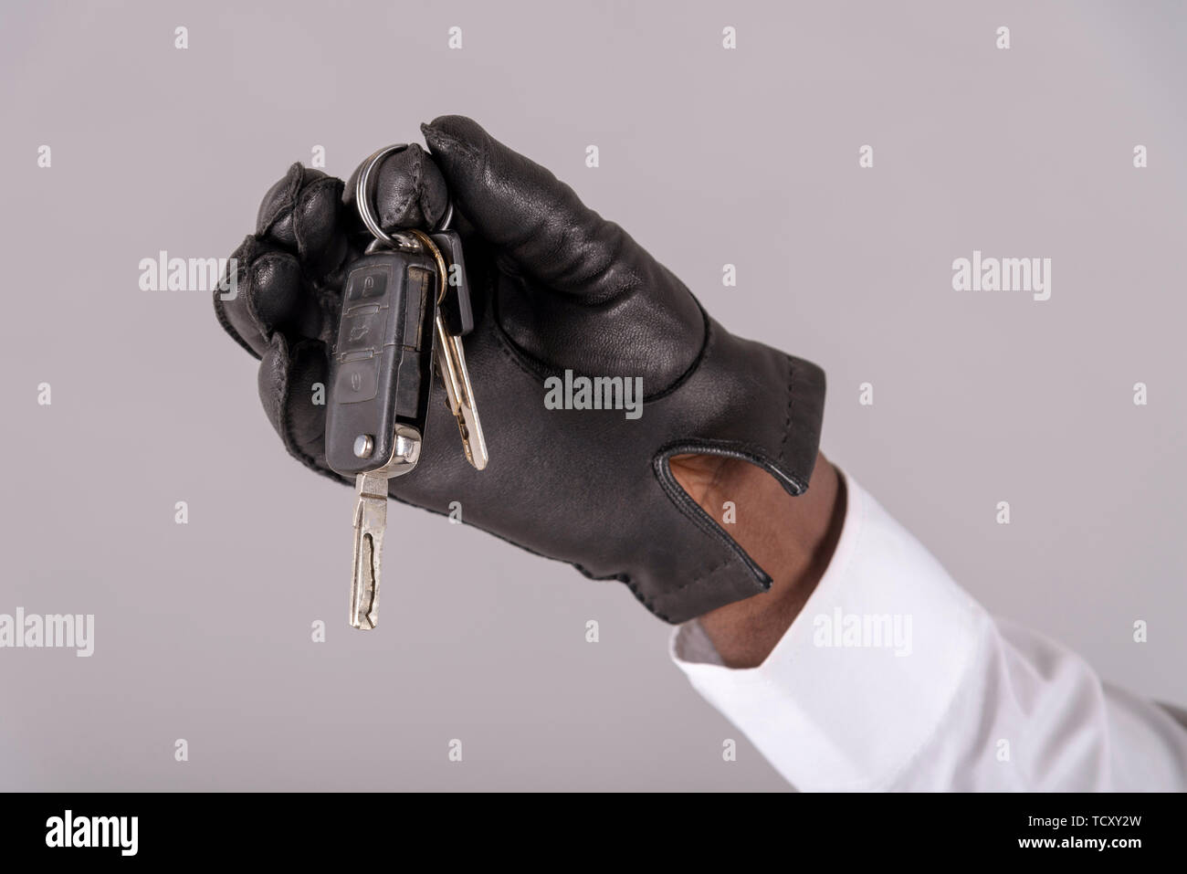 England, UK. May 2019. Man's hand wearing a black leather glove holding ignition keys for a vehicle, Stock Photo