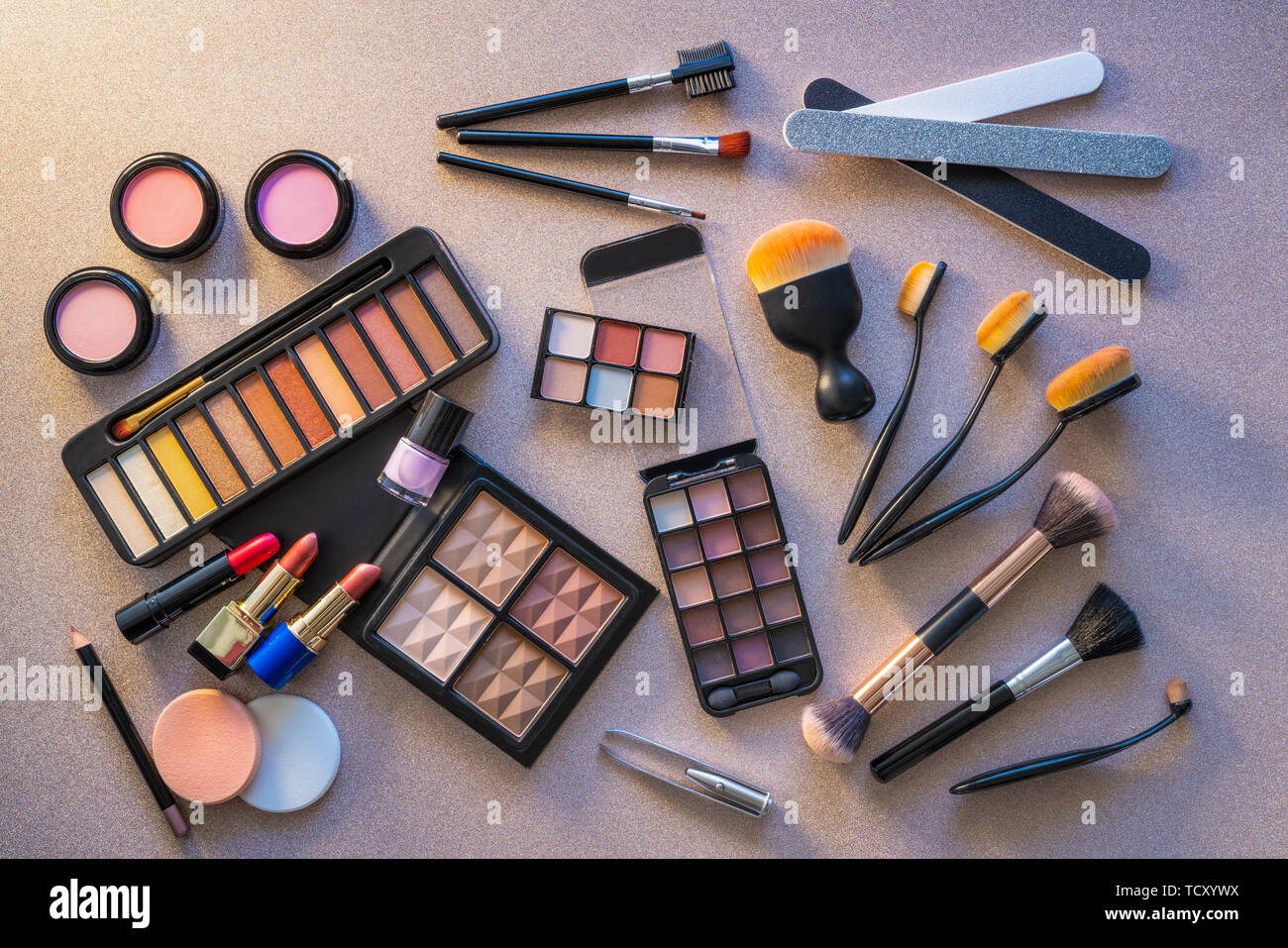 Cosmetics makeup lipstick eye shadows arrangement on glitter silver table Stock Photo