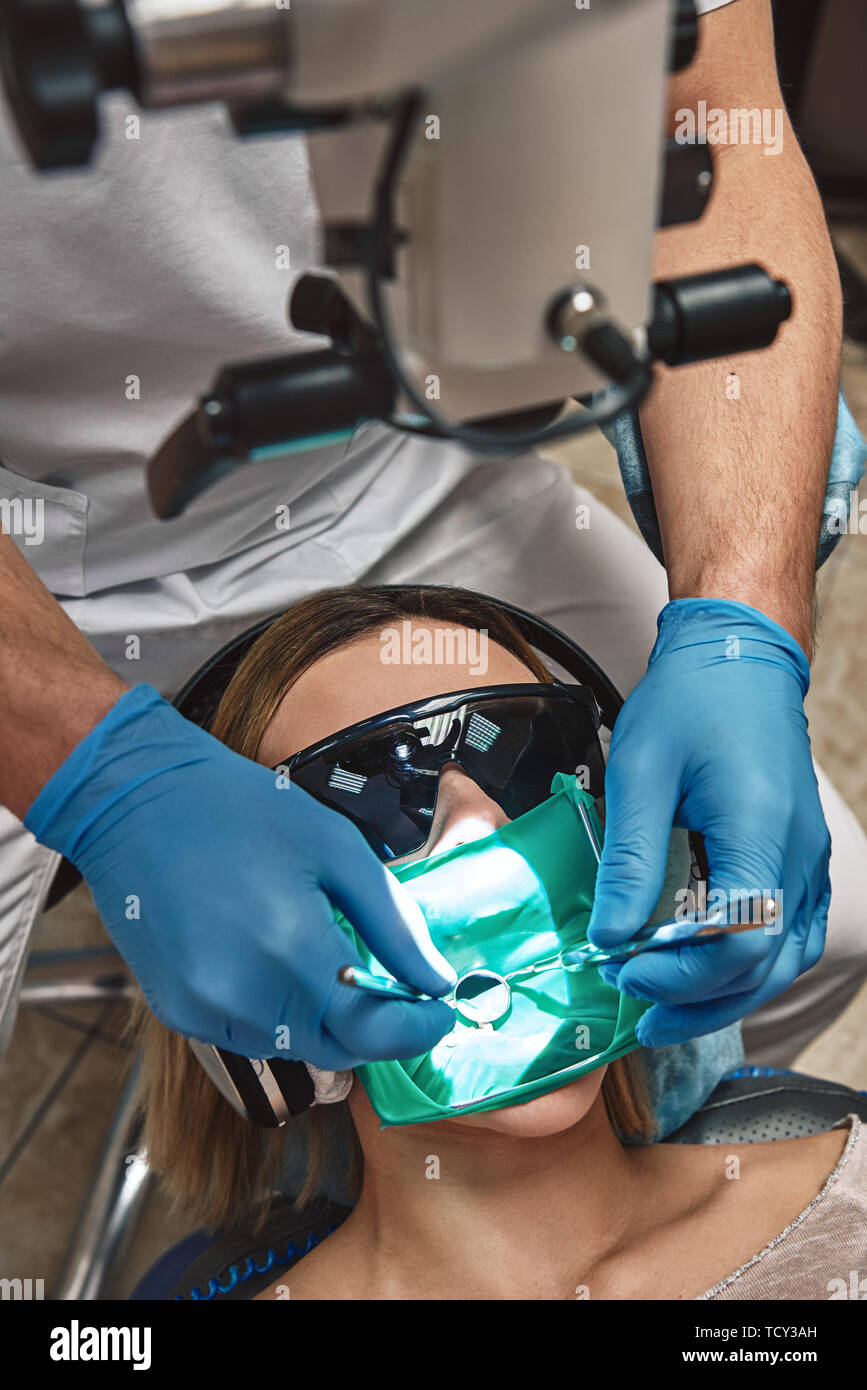 Portrait of female patient in glasses with opened mouth. She has a bit