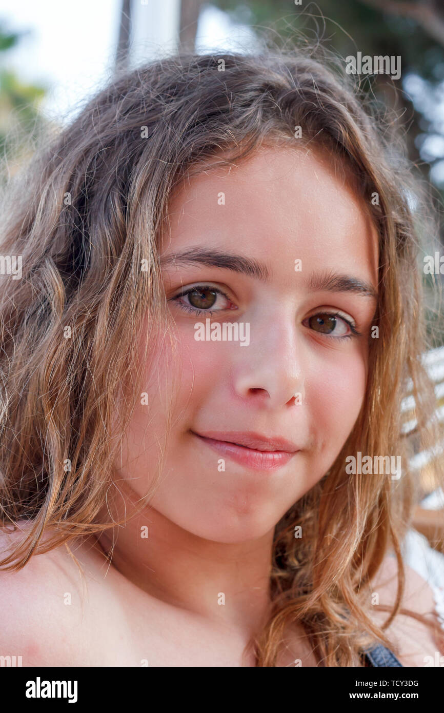 Portrait of pretty teenager girl with long curly hair Stock Photo - Alamy