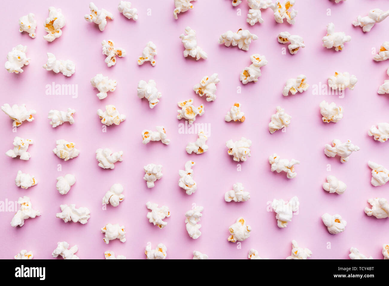 Fresh popcorn isolated on pink background top view. Composition with copy space. Stock Photo