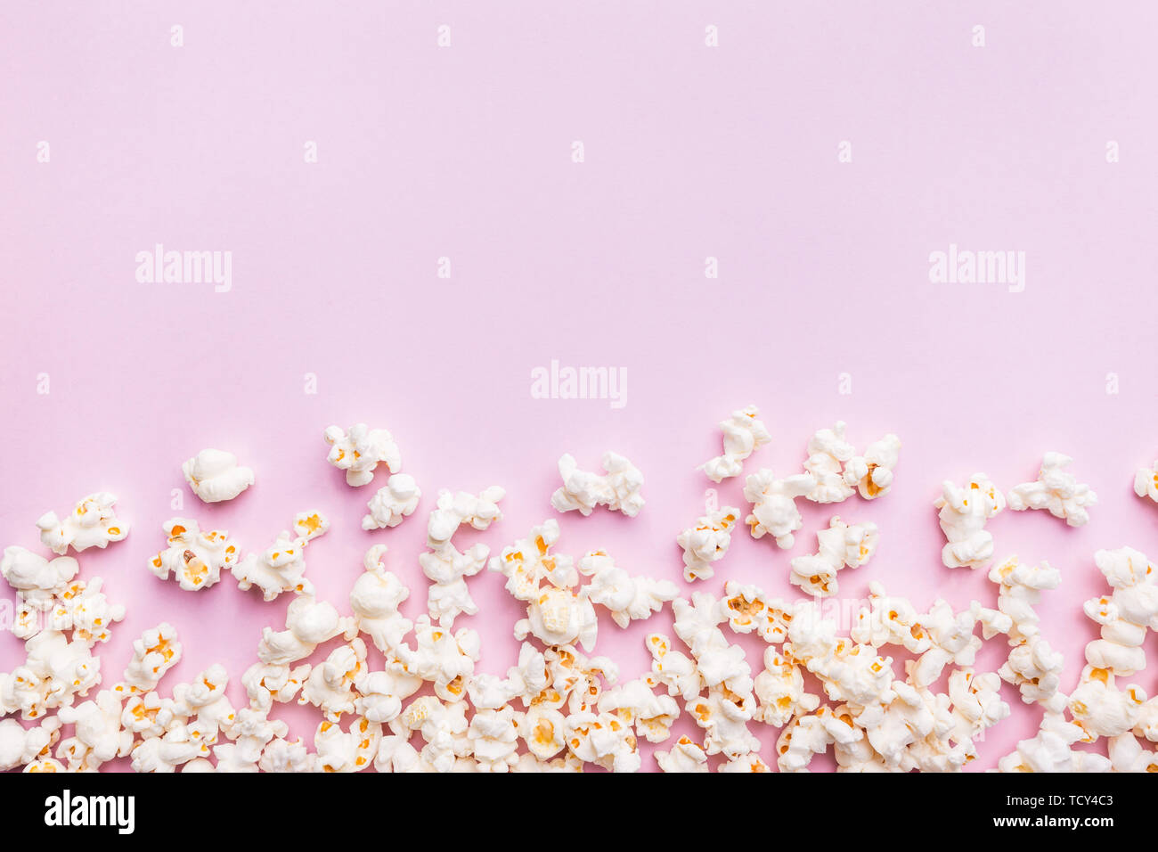 Fresh popcorn isolated on pink background top view. Composition with copy space. Stock Photo