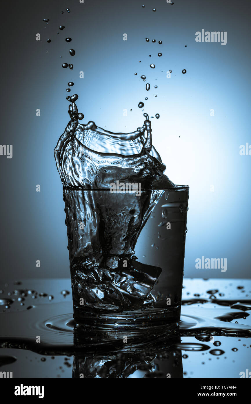 An ice cube splashing into a refreshing drink Stock Photo - Alamy