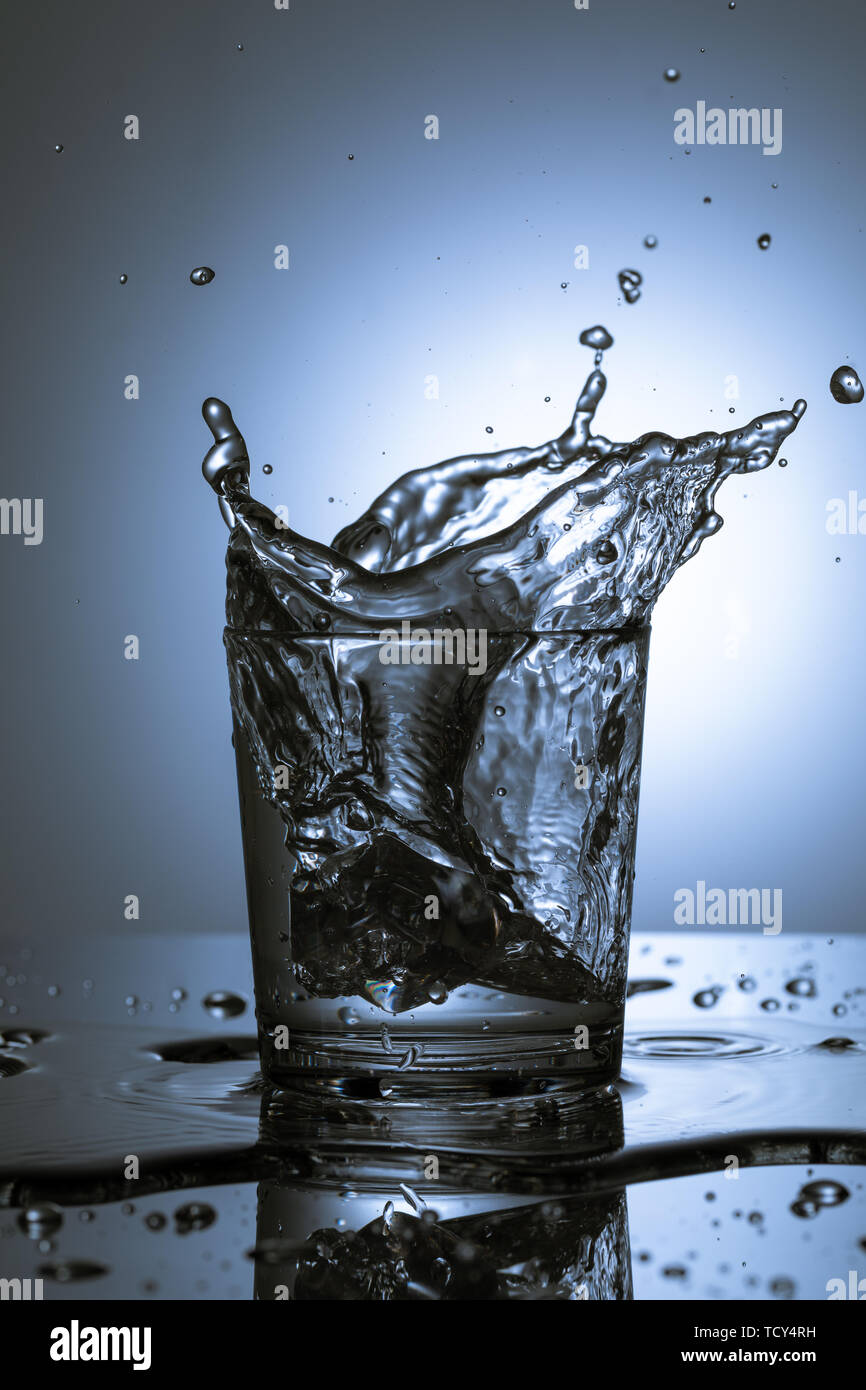 An ice cube splashing into a refreshing drink Stock Photo - Alamy