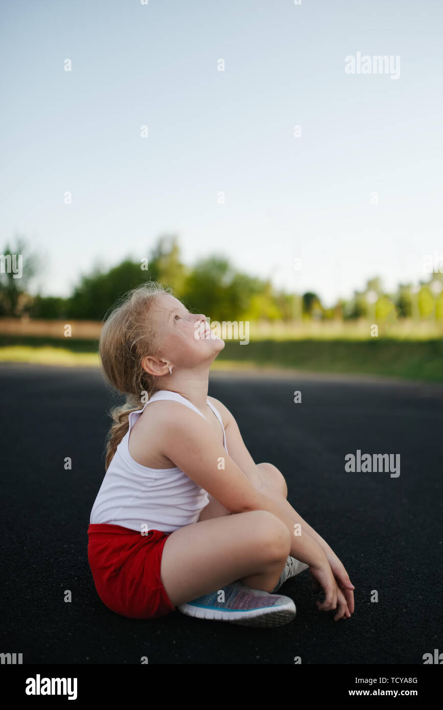 happy girl sitting on floor outdoors Stock Photo - Alamy