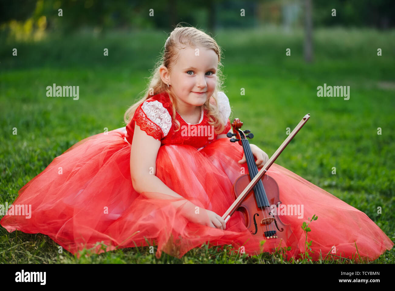 happy girl plays violin in summer park Stock Photo - Alamy