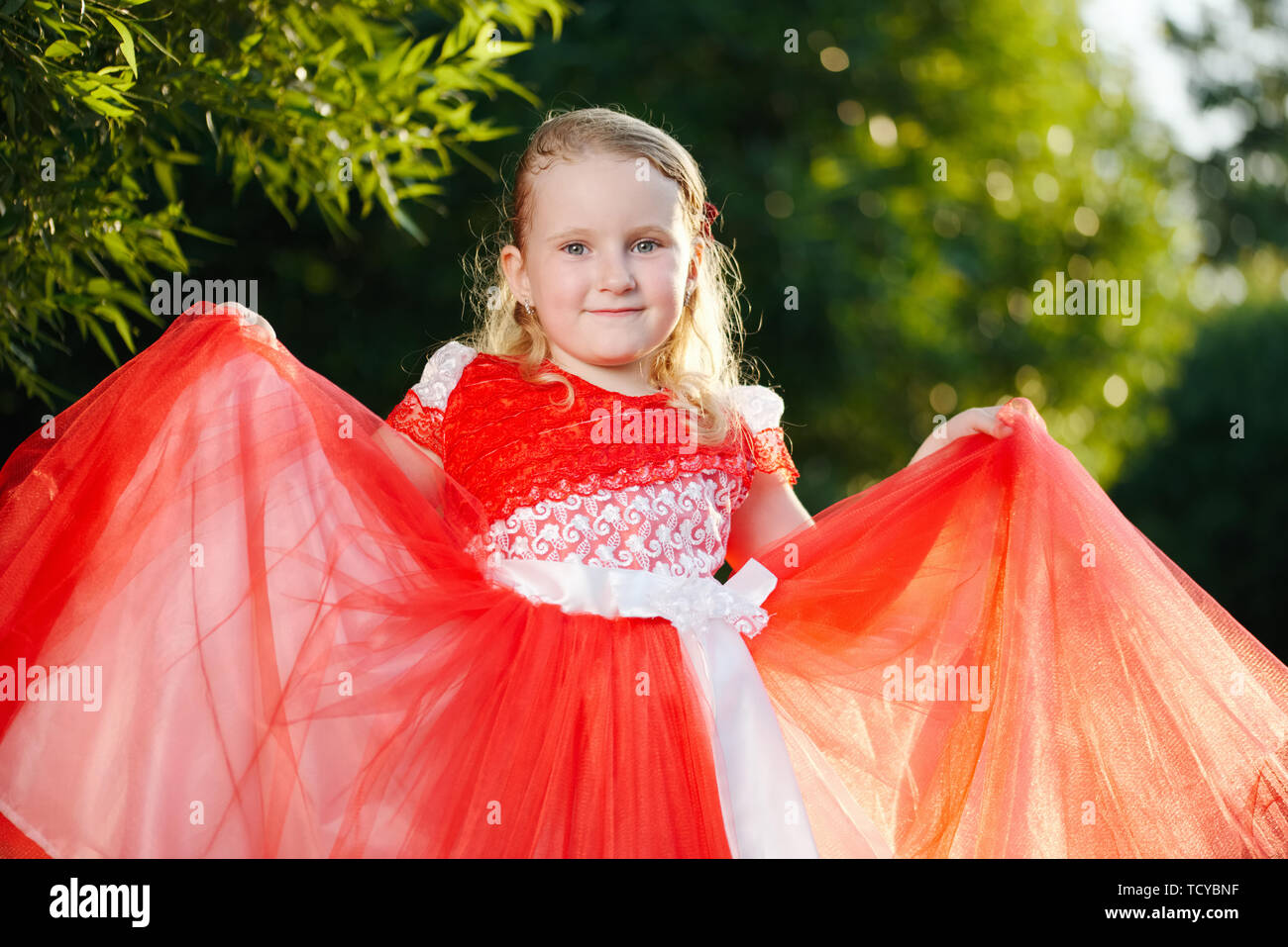 girl with beautiful red dress in park Stock Photo