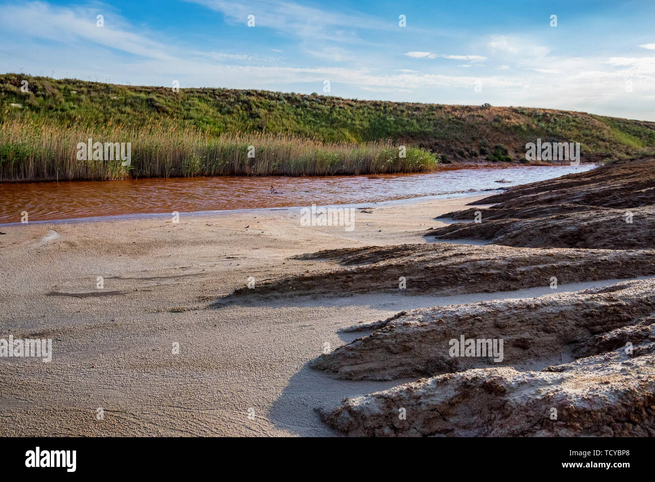 View of small red water river full of iron in beautiful steppe Stock Photo