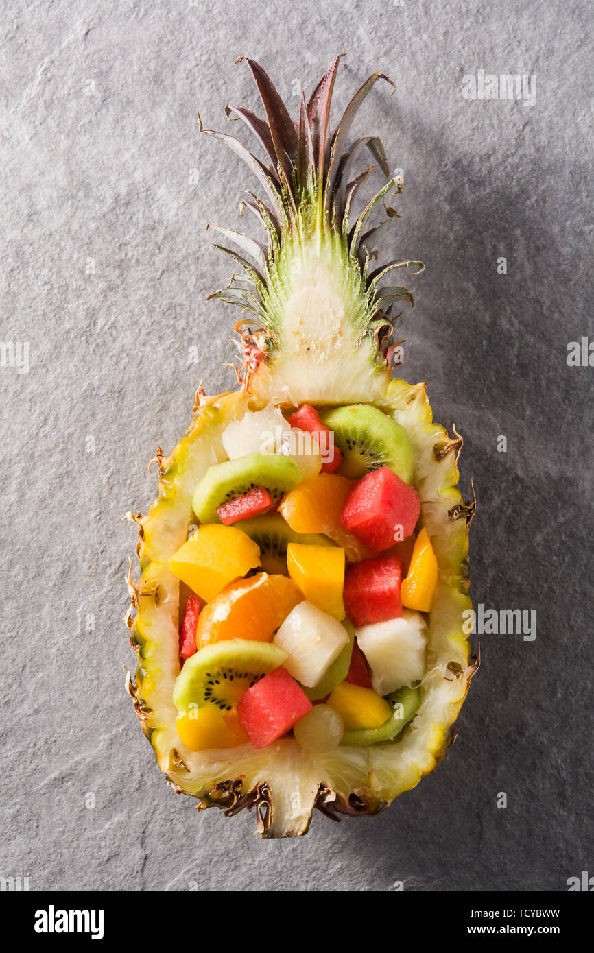 Mix fruit served inside pineapple on gray stone background Stock Photo ...
