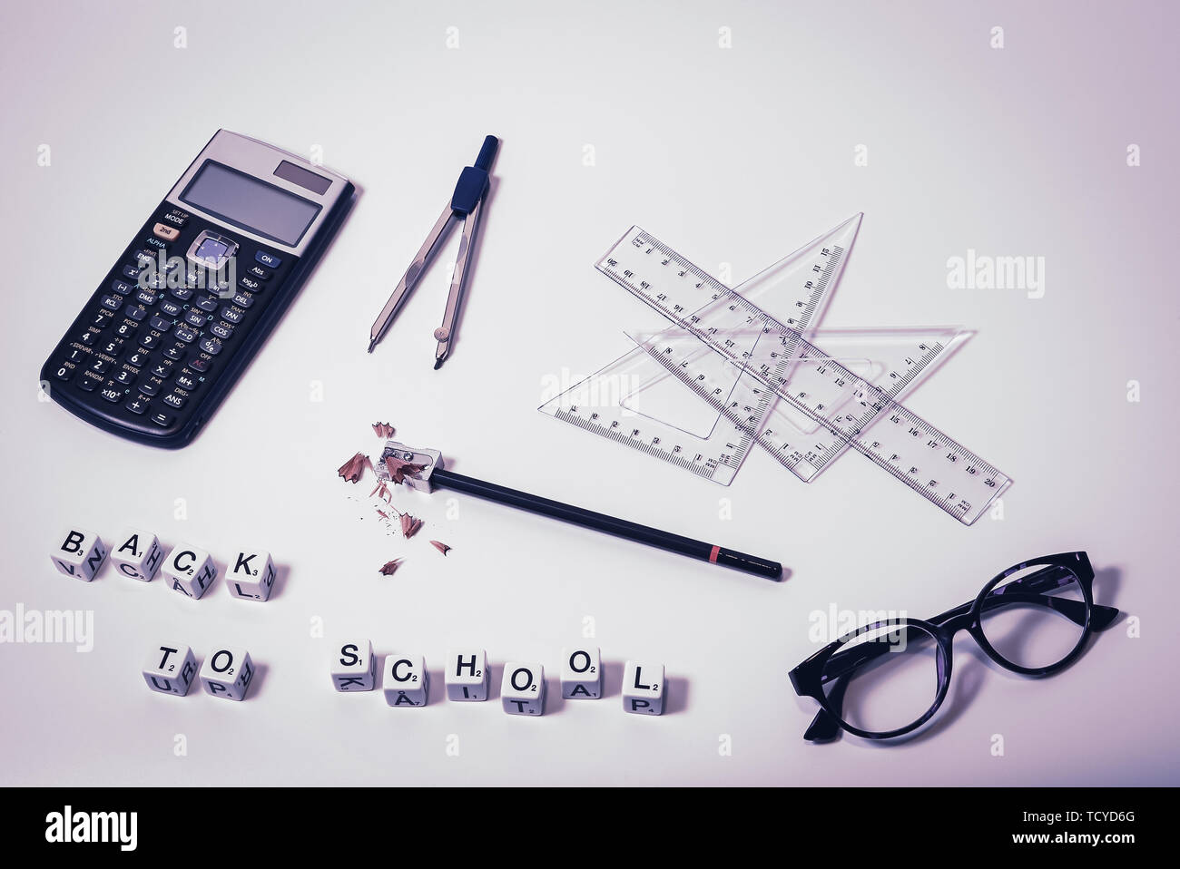 Top view of school supplies on white background with scrabble letters in the words back to school - Concept of college student, university education Stock Photo