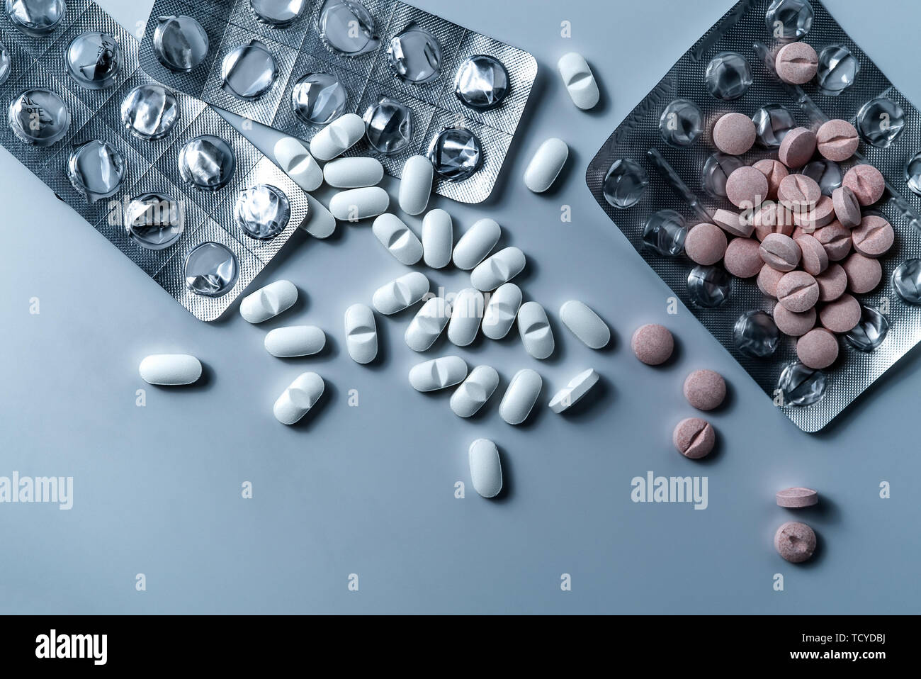 Top view of many prescription drugs, medicine tablets or vitamin pills in a pile and empty blister packs - Concept of healthcare, opioids addiction Stock Photo